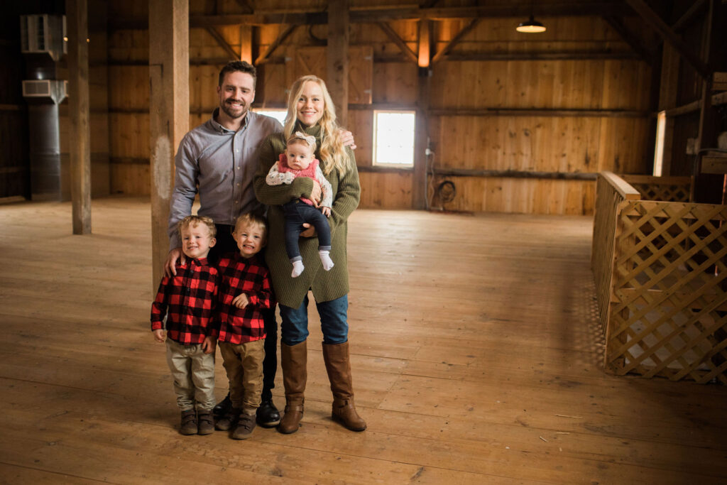 Hughes Farm Family standing in barn
